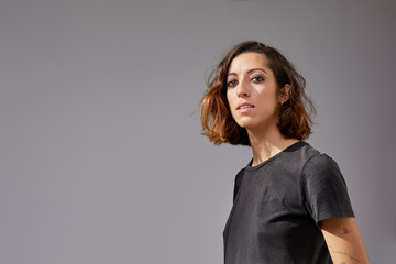 Portrait of a young woman in front of a grey background