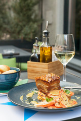 Roasted pork belly meat served with glass of white wine