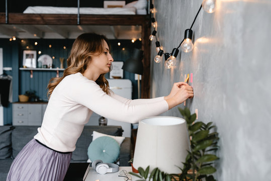 Woman attaching sticky notes to wall