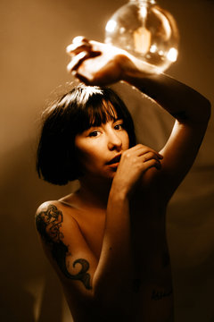woman playing with a light bulb and light