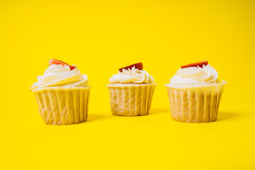 Cakes with white cream and strawberry filling on a yellow background. Baking and sweets.
