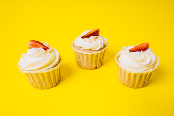 Cakes with white cream and strawberry filling on a yellow background. Baking and sweets.