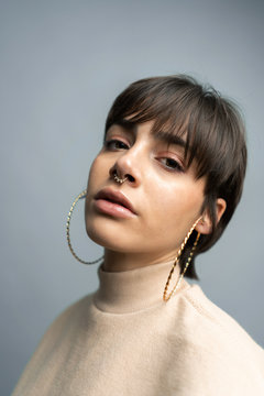Trendy young brunette in golden accessories