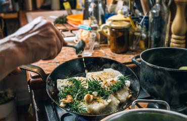 Food: Frying fish with herbs in a pan