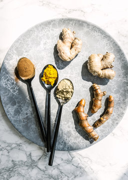 Spoonful of spices and ginger, turmeric on plate