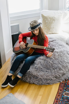 Overhead shot of Beautiful Young Teenager Playing Guitar at Home