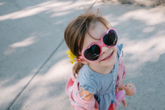 little girl wearing heart sunglasses
