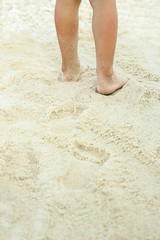 beautiful legs on the sand by the sea