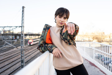 Cool young brunette pointing at camera