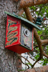 Colourful birdhouse with troll as guard