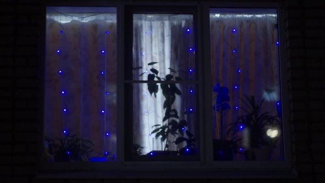 Christmas garlands sparkle on the Windows of multi storey houses in the metropolis