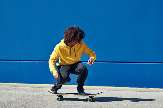 Young ethnic man on skateboard outdoors