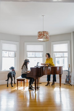 Young Teen Girl Playing Piano with Mother