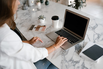 Crop lady using laptop at marble table