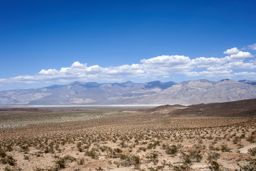 Mojave Desert. In southern California, southeast of Sierra Nevada, north and east of Los Angeles, North America. Rocks are brown and gray. Clouds in the blue sky