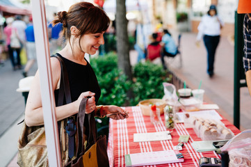 Woman Paying A Vendor At Farmers Market