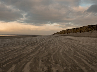 Norderney, Germany. 7 December 2019. Sandy beach on the North Sea coast on a windy winter afternoon in warm light.