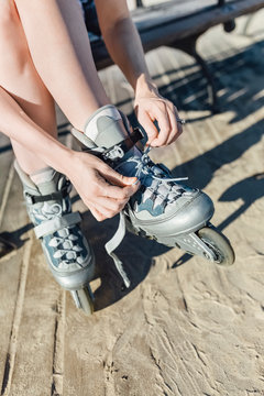 Close up of an Anonymous Woman's Hands Fixing Laces on Roller Blades Before Skating. Cool Stock Pictures