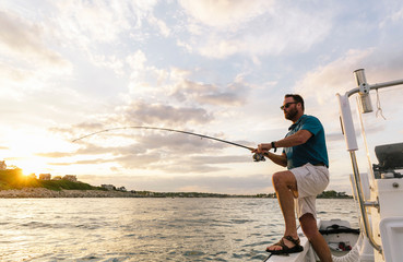 Landscape of Man Reeling up a fish on his Boat in Massachusetts, USA