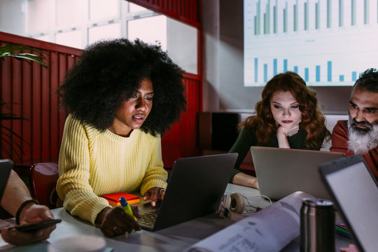 Afro casual woman using laptop in meeting room - Powered by Adobe