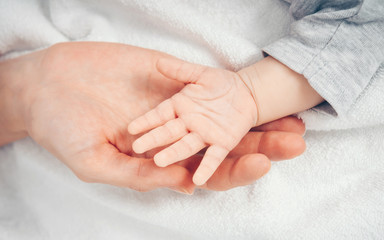 Close up baby hand on mother's hands