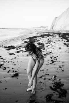 young woman feeling totally free dancing naked on the beach