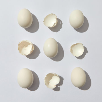 Composition of whole eggs and eggshell halves on a gray background with copy space. Flat lay