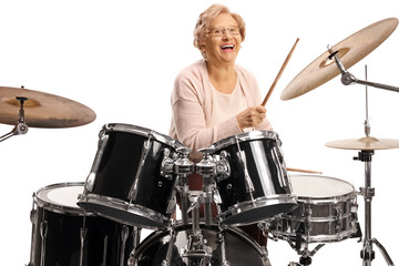 Happy senior woman playing drums and laughing