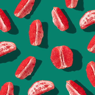 Half and pieces of grapefruit presented on a green background. Pattern as a layout for your ideas. Flat lay