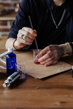 Perfumer mixing ingredients at table
