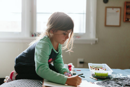 child writes letter and draws picture for dad