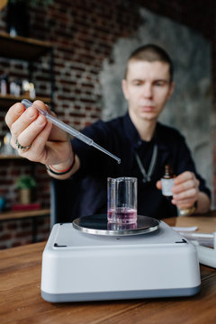 Perfumer mixing ingredients at table