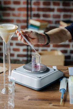 Perfumer mixing ingredients on scales