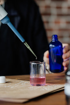 Perfumer mixing ingredients at table