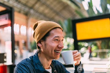 Asian happy man having a coffee in the airport terminal