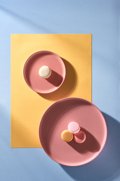 Minimal flatlay of macaroons on pastel plates.