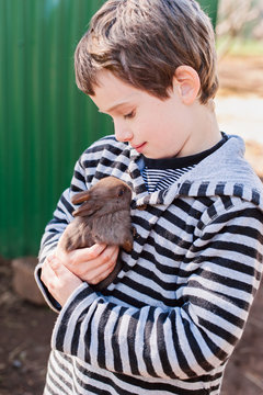 Happy child cudding a baby rabbit