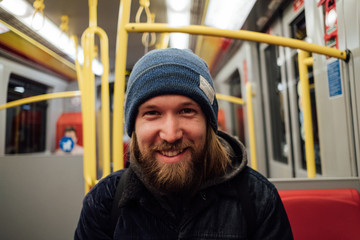 Smiling portrait of a man sitting in subway train