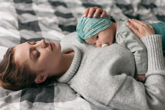mother lies with the child on the bed