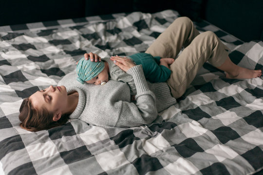 mother is lying on the bed with the baby