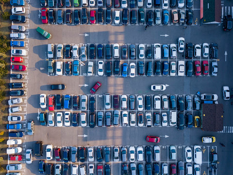 Aerial view from drone open parking with colorful cars on a gray