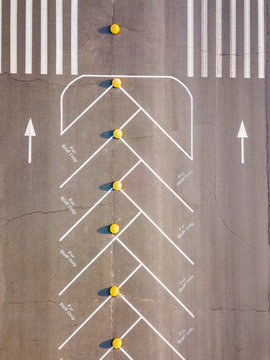 Road marking pattern, aerial view from drone empty parking lot with painted lines for stuff only on a gray asphalt background. Top view.