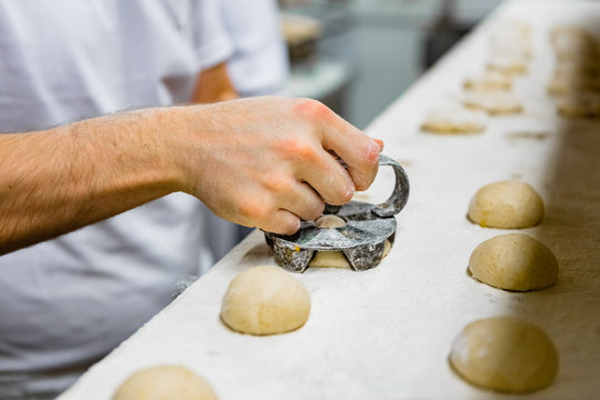 Pressing Iron Mold on Small Bread Loaves
