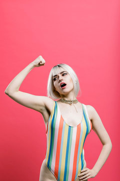 Confident woman in swimwear flexing muscles