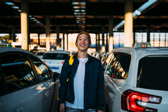 Young Chinese man waiting a taxi in the parking lot