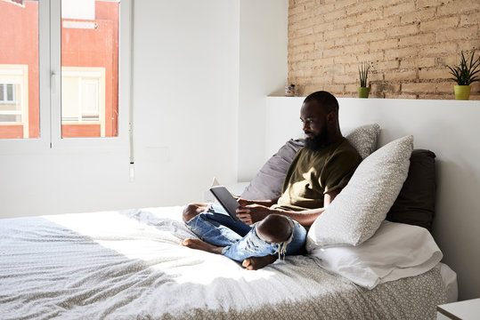 Black afro bookworm reading bed.