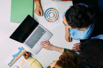 Top view of business team in meeting room using laptop and checking documents