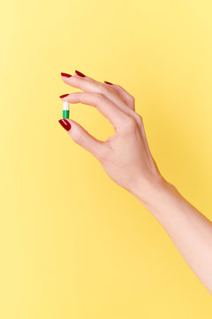 Hand holding a capsule