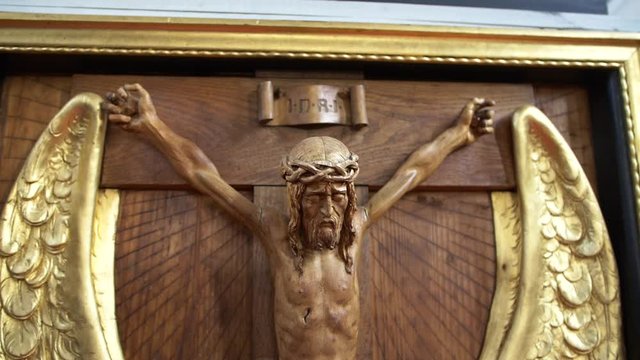 Wooden statue of Jesus Christ dying on cross, moving shot.