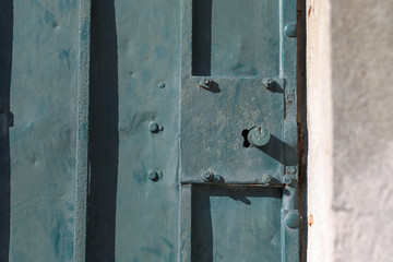 Old rusty metal lock and keyhole on a old iron door as a beautiful vintage background. Old rusty green gate